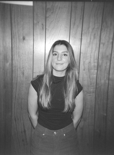 Eilish smiles in front of a wood wall