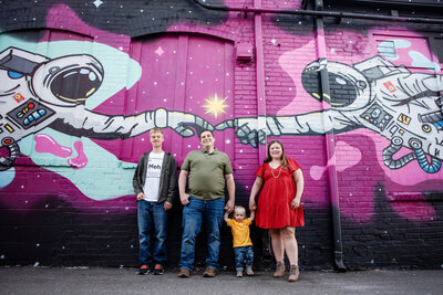 st-louis-mini-sessions-family-in-front-of-mural-wall-with-astronauts
