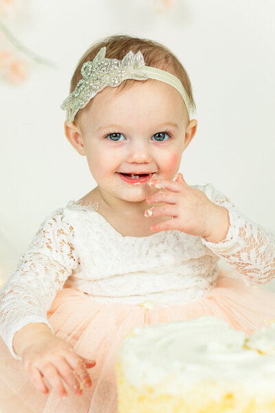 Baby girl celebrating her 1st birthday with cake smash photo session in Helen Hill Photography studio in Raleigh, NC.