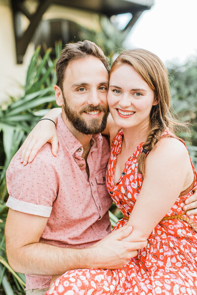 couple wearing red and pink smile at camera