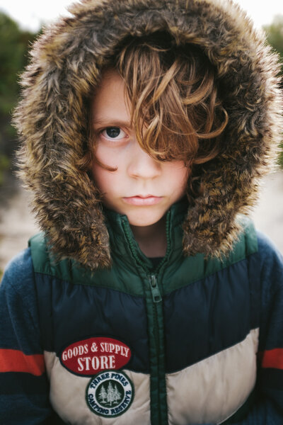 Young boy in wooly hoodie looking at camera