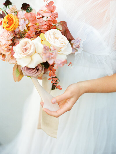 Gorgeous bride's bouquet with peach, oranges and red flowers