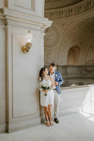 bride and groom standing in SF City Hall