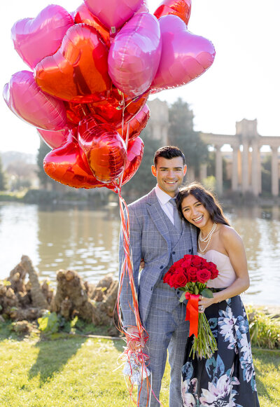 couple posing for valentine's day with heart balloons and red roses at palace of fine arts san francisco, laughing and smiling genuine and romantic, photo by Anastasiya Photography - San Francisco Photographer