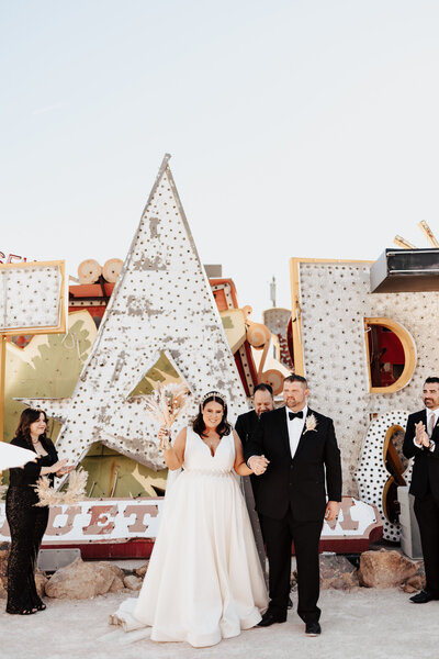 A smiling couple at their Neon Museum wedding, enchanted by Kristie Smith's personalized harp wedding songs.