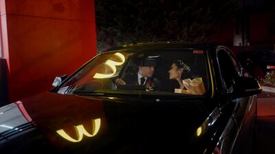 groom opens and sprays Champaign on wedding day surrounded by bride and wedding party