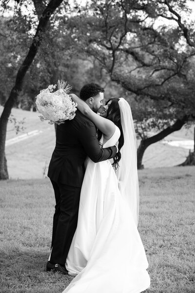 An Austin-based wedding photographer captures a breathtaking moment as a bride and groom gracefully dance in a rustic barn.