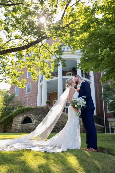 Bride and groom kiss in front of venue