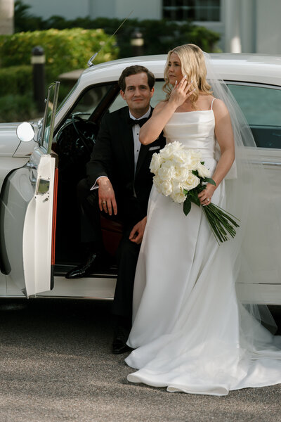 bride and groom posing in front of wedding chapel