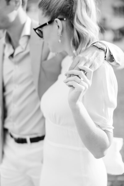 A couple during their editorial engagement session in black and white where you van see her wedding ring by Angelika Krug Photo & Film