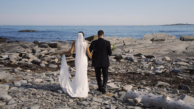 Bride and Groom walk towards the ocean on Peaks Island Maine