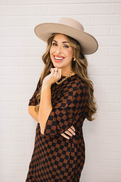 woman smiling while wearing a wide brimmed hat