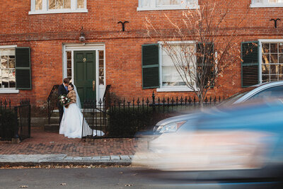 Photo of Bride and Groom from across street with car blurring by