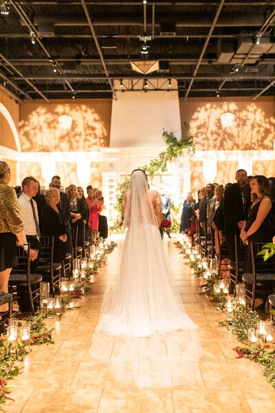 A bride gracefully walks down the aisle, radiating joy and elegance during a beautiful wedding ceremony.