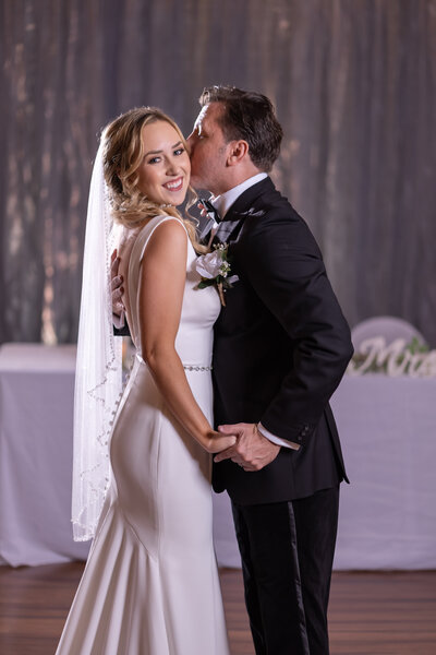 Romantic first dance as the couple shares a sweet kiss on the beautiful dancefloor at The District Event Venue in Clearwater, Florida - A magical moment of love and togetherness