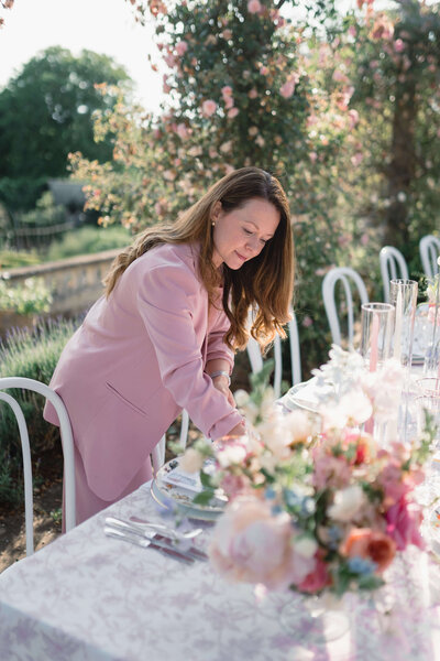 top wedding planner emma westacott perfecting a wedding table design with a pink colour scheme for a garden wedding held at euridge manor