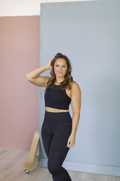 Brooke poses wearing all black Zyia Active apparel