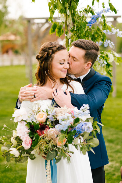 Jackson Hole photographers captures groom hugging bride during forest bridals