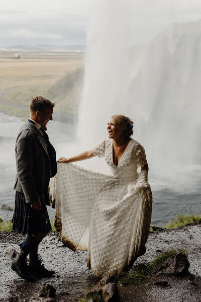 couple laugh under waterfall
