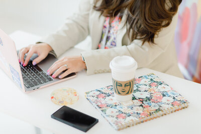 Woman Working on Computer with Starbucks