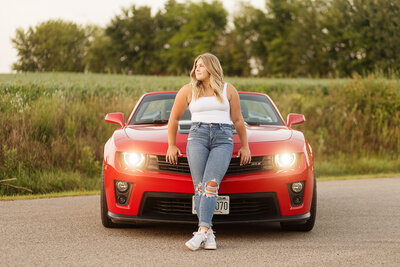 Girl posing with her red sports car.
