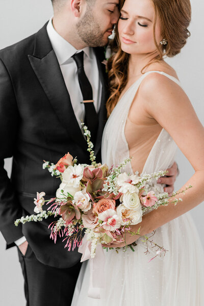 bridal couple portrait with bouquet in blush and white.