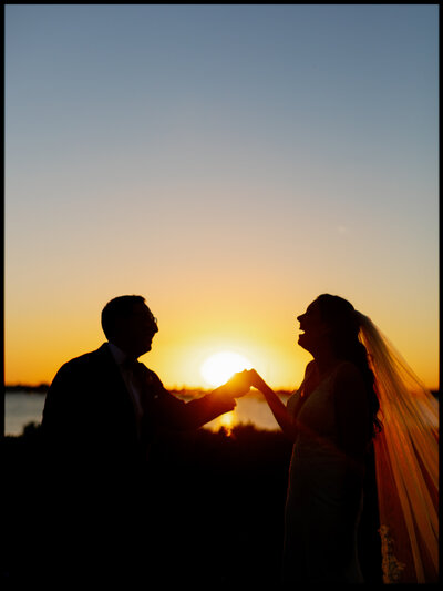 Bride and groom laughing together at sunset during their Selby Gardens wedding, captured by Florida wedding photographer Jake Ford.
