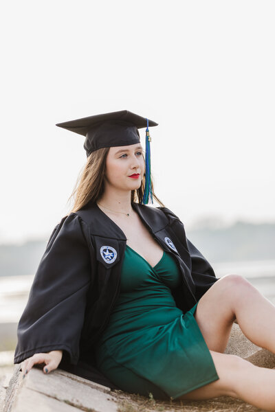 Upcoming high school senior poses for a photo in a cap and gown before their graduation