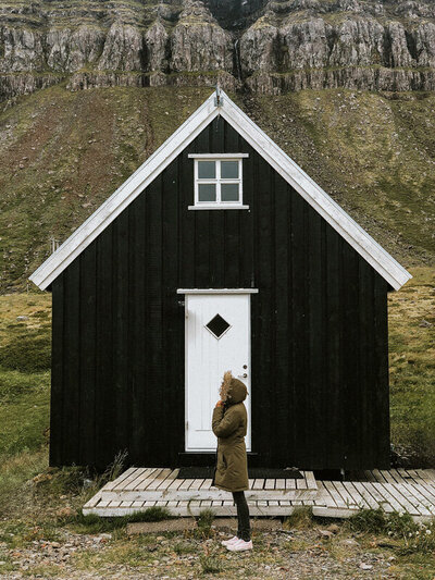 Iceland elopement and wedding photographer Bettina Vass is standing in front of a turf house in north Iceland