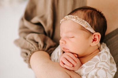 Springfield MO newborn photographer captures mom holding sleeping baby girl in floral crown