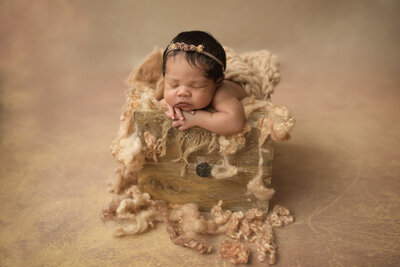 newborn in kinpose in houten prop