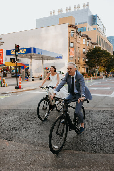 Nontraditional Boston wedding where the couple is riding bikes through the city downtown