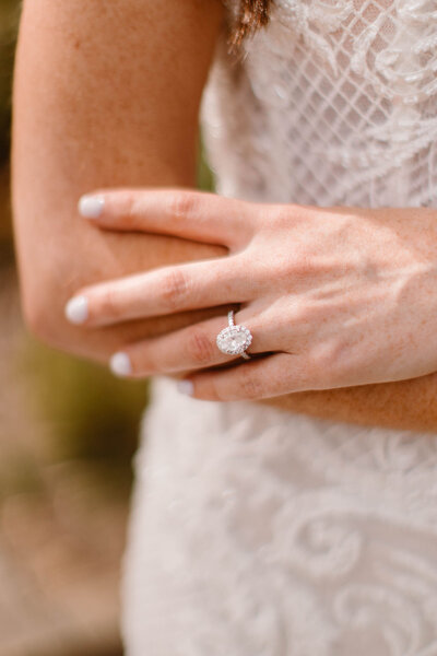 close up of lace dress and oval diamond engagement ring