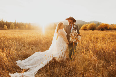 bride and groom posing in field