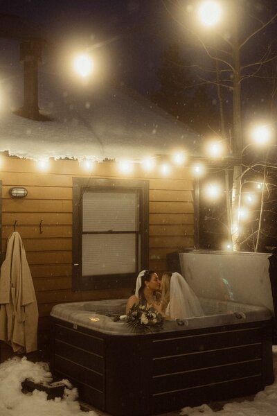 Two Brides enjoy a hot tub while a colorado wedding photographer takes their picture.