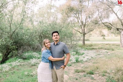 Engaged couple cozy up and pose for photos in the woods area at Talbert Regional Park in Costa Mesa