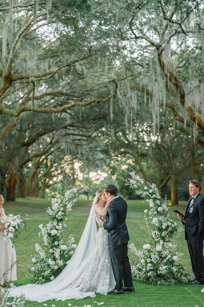 bride and groom share their first kiss at legare waring house in charleston