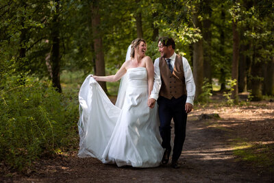 spontane trouwfoto bruidspaar wandelend in bos