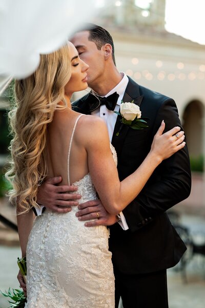 Groom kissing bride on the cheek in an embrace