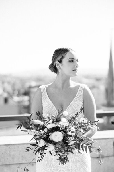 Bride holds flowers on rooftop overlooking PA State Capitol Building in Harrisburg