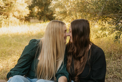 A couple smiling and sitting nose to nose 