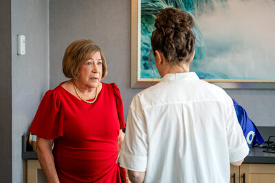 Mother of the bride in red dress speaking with Bride during preparations – photographed by wedding photographer Niko Coric – Lumen Clarity Media
