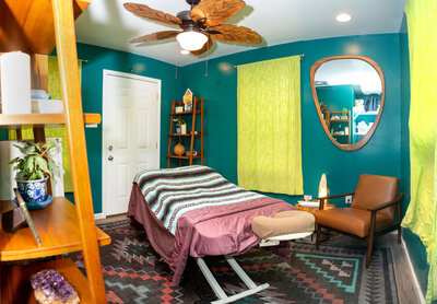 Message therapy table in a green and yellow calming massage room