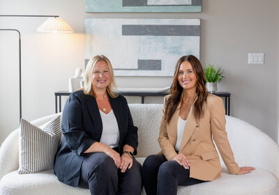 two real estate agents smiling and sitting