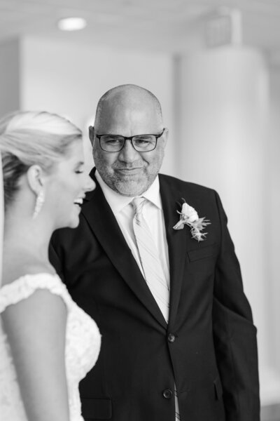A close up image in black and white of an emotional father looking at his beautiful daughter on her wedding day