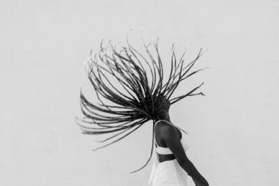 A Black woman with braids swooping through the air