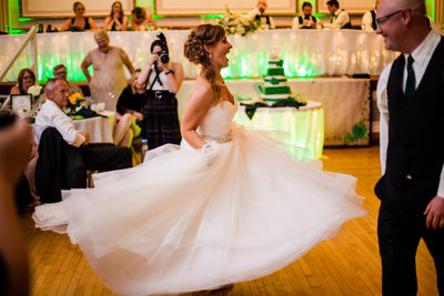 Bride twirls her dress while she and groom dance at their Masonic Temple wedding in Erie PA