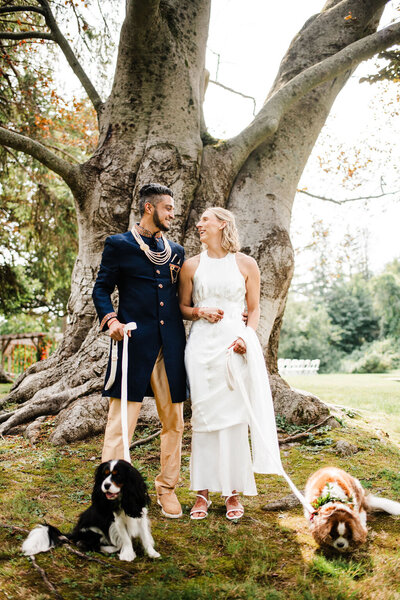 Bride and Groom standing in front of tree with two dogs, Blended wedding at Peirce Farm at Witch Hill