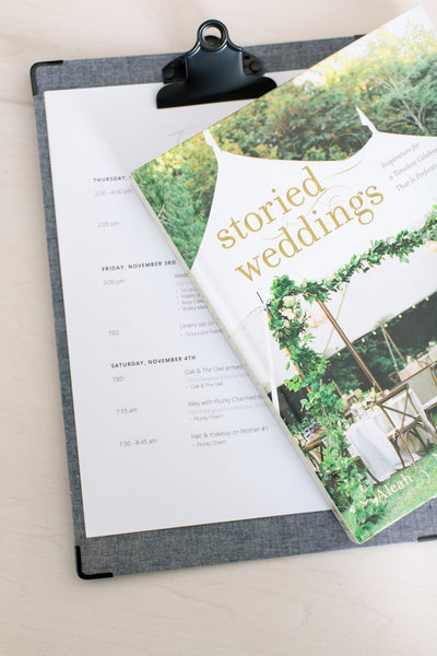 A wedding vendor clipboard and magazine with timeline details.