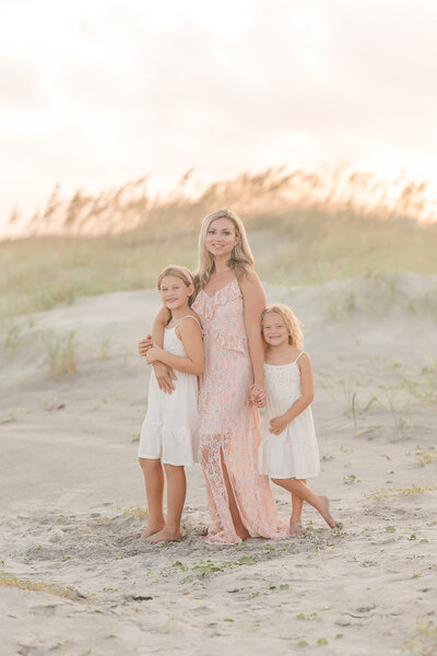 two little girls wearing brown velvet dresses in front of a sunset on edisto island south carolina